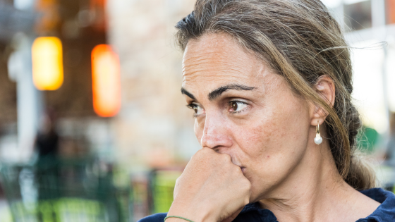 Women with her fist on her mouth contemplating.