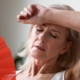 Exhausted woman with her arm over her forehead displaying stress and weight gain.